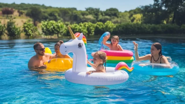 Family enjoying a variety of colorful float options in a sunny pool during summer.