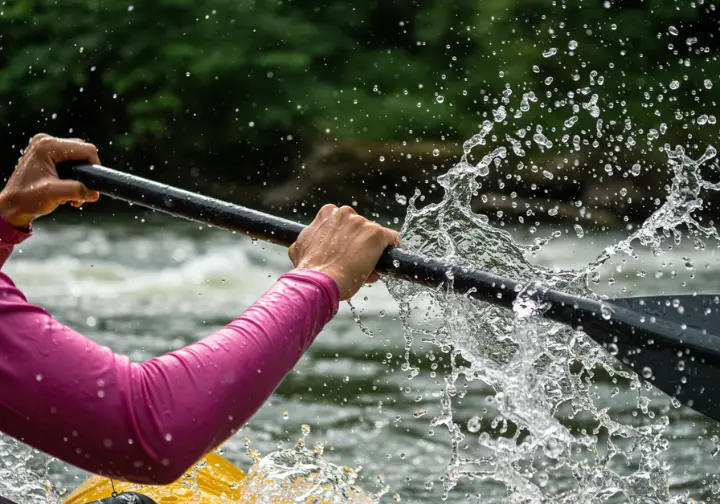 Close-up of hands paddling during a Savegre River white water rafting adventure.
