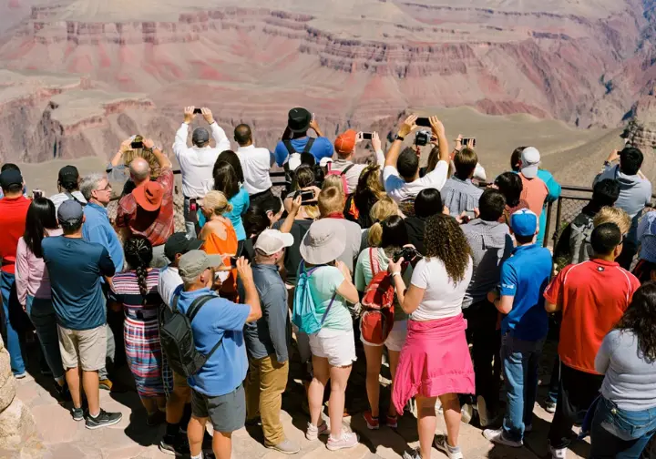 Package cons drawbacks: Large tour group crowded at a popular Grand Canyon viewpoint, illustrating a potential drawback.