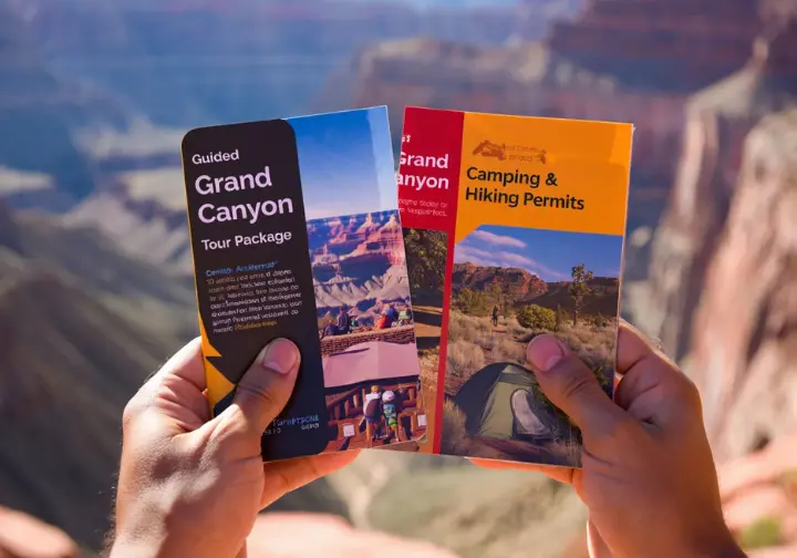 Making your decision: Hands holding brochures comparing a guided Grand Canyon package versus DIY options.