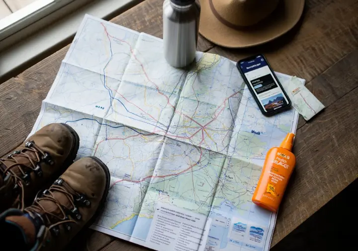 Plan your Moab adventure: Essential planning items including map, boots, water, sun protection, and reservation tools.