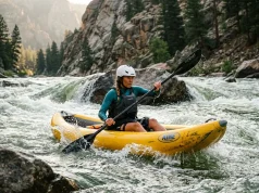 Best Inflatable Kayaks for Rivers We’d Run Paddler running an inflatable kayak through a river wave train on a sunny day