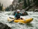 Best Inflatable Kayaks for Rivers We’d Run Paddler running an inflatable kayak through a river wave train on a sunny day