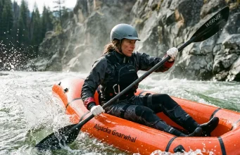 Best Packrafts for Every River and Trip 2026 Paddler in a whitewater packraft punching through a Class III wave train on a snowmelt river