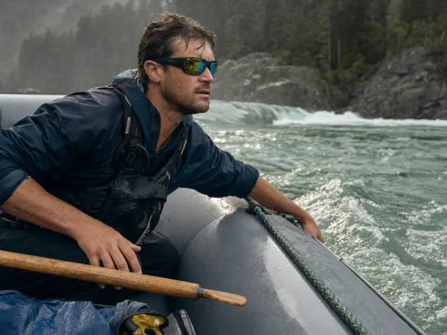 0-best-polarized-sunglasses-for-rafting-hero Rafter in a raft reading the river line wearing polarized Smith Optics sunglasses on a gray morning