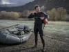 How to Layer for Cold Water Rafting Before You Swim Rafter layering up at a cold river put-in on a gray spring morning before launch
