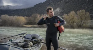 How to Layer for Cold Water Rafting Before You Swim Rafter layering up at a cold river put-in on a gray spring morning before launch