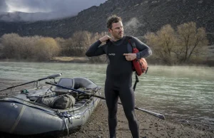 How to Layer for Cold Water Rafting Before You Swim Rafter layering up at a cold river put-in on a gray spring morning before launch
