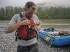 River Knife Buying Guide Why Sheaths Fail First Boater clipping a CRKT Bear Claw river knife onto his PFD lash tab at a gravel-bar put-in