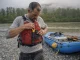 River Knife Buying Guide Why Sheaths Fail First Boater clipping a CRKT Bear Claw river knife onto his PFD lash tab at a gravel-bar put-in