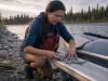 The 4-3-2-1-1 River Rescue Kit Guides Actually Carry Boater counting the locking carabiners in her river rescue kit on a raft frame at the put-in