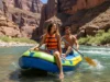 Raft Pin Kit Guide: For Rafts, Kayaks & Packrafts A fit couple in their late twenties rafting down a sunny river canyon, embodying the spirit of whitewater adventure.