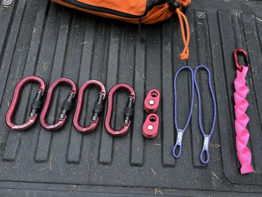 The full 4-3-2-1-1 river rescue kit laid out on a tailgate: carabiners, pulleys, prusiks, webbing, rope