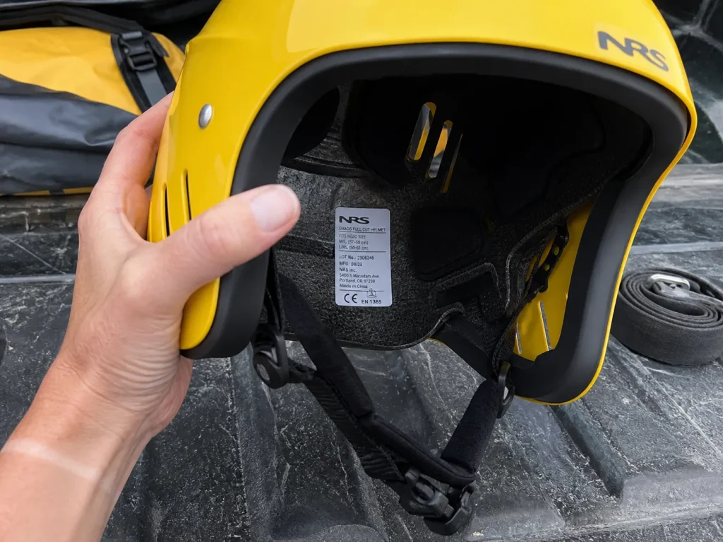 Close-up of the CE EN 1385 certification label inside an NRS Chaos rafting helmet shell