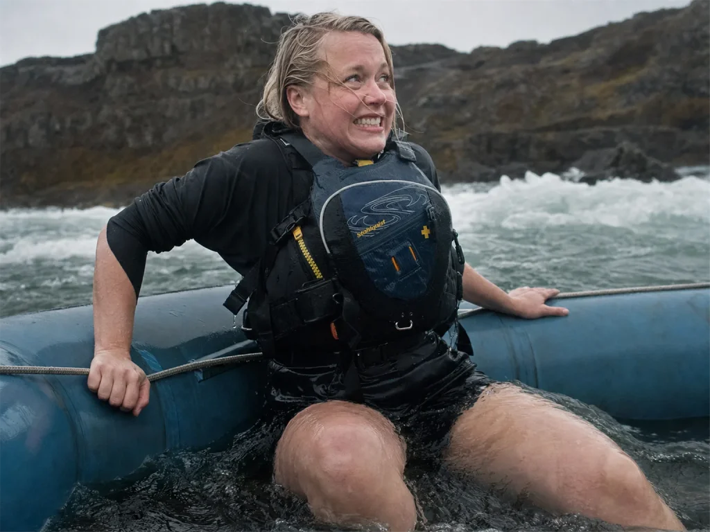 Swimmer back on the raft tube after a swim, her Stohlquist Descent PFD riding high on her chest