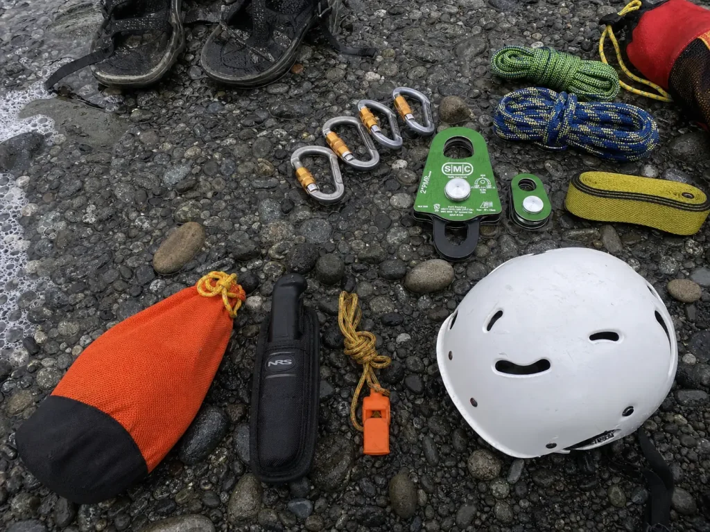 Starter river rescue kit next to a full rescue rack on a gravel bar, showing what a weekend boater needs