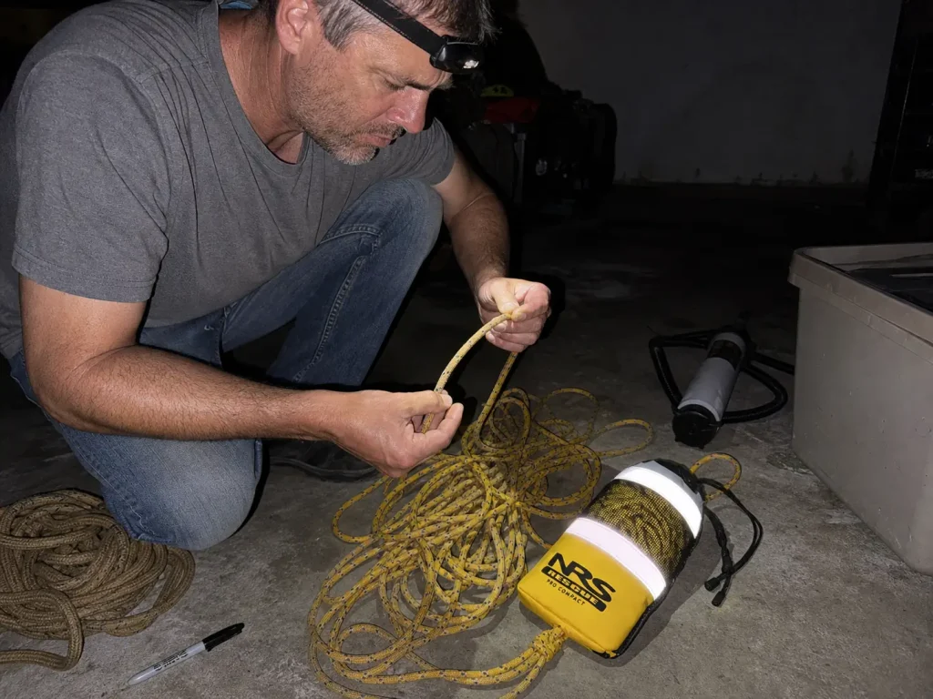 Inspecting a sun-faded rescue rope in a garage at the end of the season before storing it