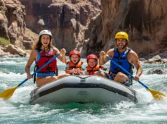 Best Family Rafting Companies: A Data-Backed Guide A full-body shot of a happy family with two young children rafting down a sunny river, all wearing life jackets and smiling.