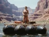 Georgie White Clark: The Technical Legacy of a Rafting Pioneer A vintage-style color photo of a woman in a leopard-print swimsuit on a massive, triple-pontoon rubber raft in the Grand Canyon.