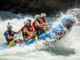 High-Side Command in Rafting: A Tactical Guide A full crew of rafters in a whitewater raft executing a high-side command, leaning hard onto the high side of the boat as it tilts in a powerful rapid.