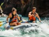 Read a River: A Hazard Identification System for Rafters A fit young couple in a raft navigate a sunny river canyon, looking ahead intently to read the water and identify hazards.