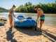 How to Rig a Raft to Flip: A Pro Guide to Safety A fit couple in their late 20s rigging a whitewater raft together on a sunny riverbank before a trip.