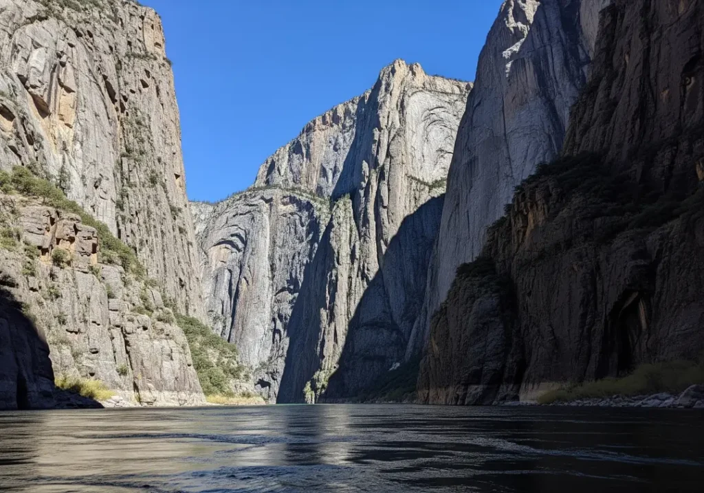 A dramatic, people-free view of the Middle Fork Salmon River flowing through the immense, sunlit granite cliffs of Impassable Canyon.