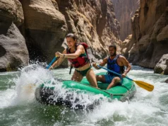 The Omo River Rafting Guide: Logistics, Permits & Grade IV A full-body shot of an athletic man and woman in their late 20s paddling a raft through rapids in the Omo River canyon, Ethiopia.