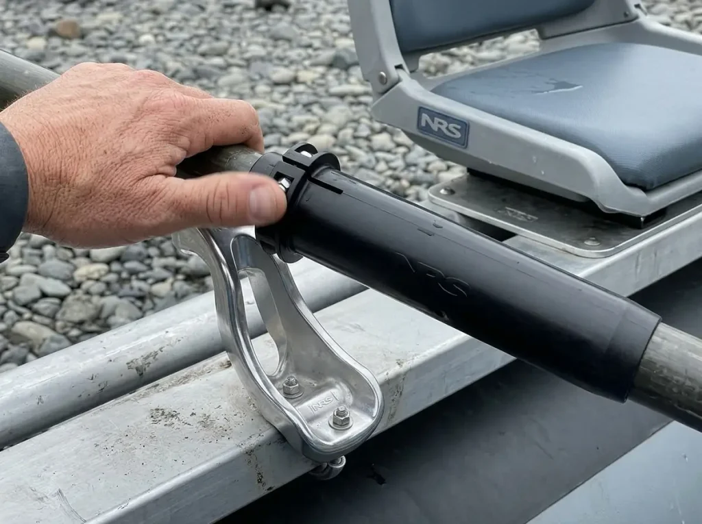 Close view of raft frame oar mount, molded oar sleeve and padded rower seat parts