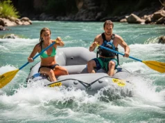 River-Rated: The Best Paddle Brand for Rafters in 2025 A fit young couple in their late 20s paddling a raft through whitewater rapids on a sunny day.