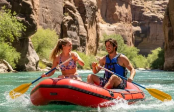 Plan Any Rafting Trip: The Systematic Planning Guide An attractive, fit couple in their late 20s wearing swimsuits and life jackets, joyfully paddling a raft on a sunny river.