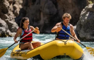 Rafting Types: A Guide to Rafts, Skills & River Classes A fit young couple in their late 20s enthusiastically paddle a bright yellow raft through splashing whitewater rapids.