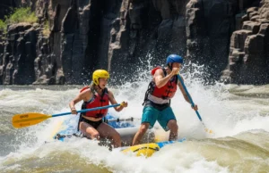 Rafting Zambezi River: A Technical Rapids Analysis (2025) A fit man and woman paddle furiously in a raft, crashing through a huge whitewater rapid on the Zambezi River, framed by the towering walls of the Batoka Gorge.