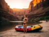 Groovers & Wag-bags: How to Poop on a River Trip A full-body shot of a woman in a bikini standing on a river beach at sunrise, looking at the canyon, representing the comfort achieved by mastering river sanitation protocols.