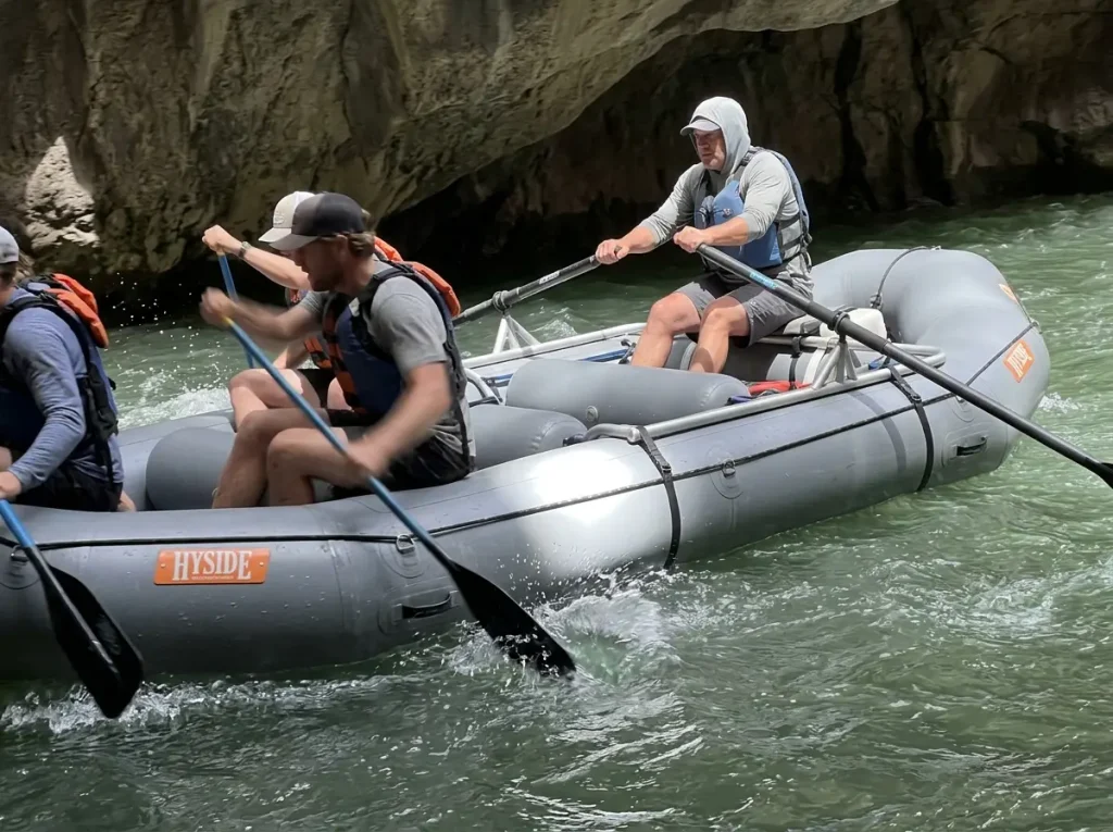 Hyside raft rigged with a stern-mount frame and a paddle crew working a rapid