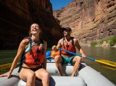 Treating Hypothermia with Raft Gear: A Step-by-Step Guide A full-body shot of a happy, fit couple in their late 20s wearing PFDs and swimwear while rafting down a sunny river.
