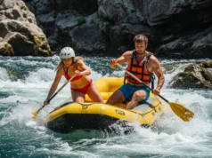 Rafting Risk by River Class: The Definitive Guide A fit young couple in a raft navigating an intense whitewater rapid, illustrating the dangers and skills involved in rafting.