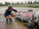 Why Rafting Gear Maintenance Isn’t a Once-a-Year Job Boater rinsing sand off an inflatable raft at a river takeout, rafting gear maintenance