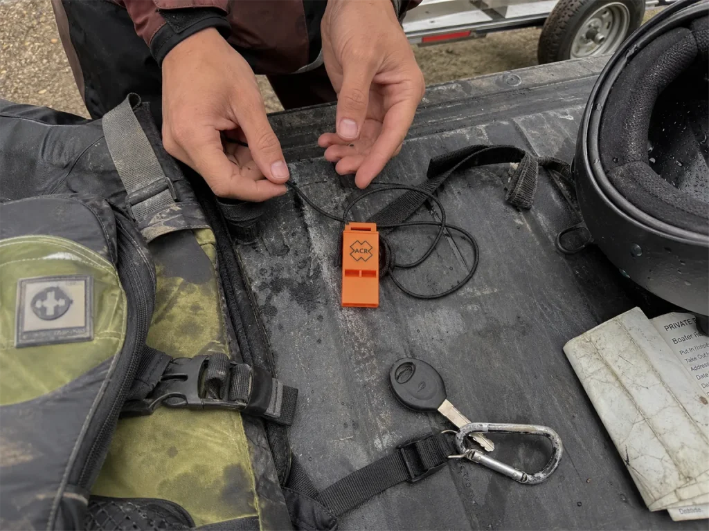 ACR WW-3 Res-Q whistle laid out with PFD and helmet during a pre-launch raft gear check