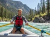 Balancing an Oar Rig: A Step-by-Step Field Guide A skilled male rafter in his early 30s confidently rows a raft down a beautiful river, perfectly demonstrating a balanced oar rig in action.