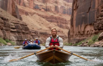 Dory vs Raft: Grand Canyon Performance & Safety Analysis A skilled male guide rows a wooden dory through a Grand Canyon rapid, with an inflatable raft visible in the background for comparison.