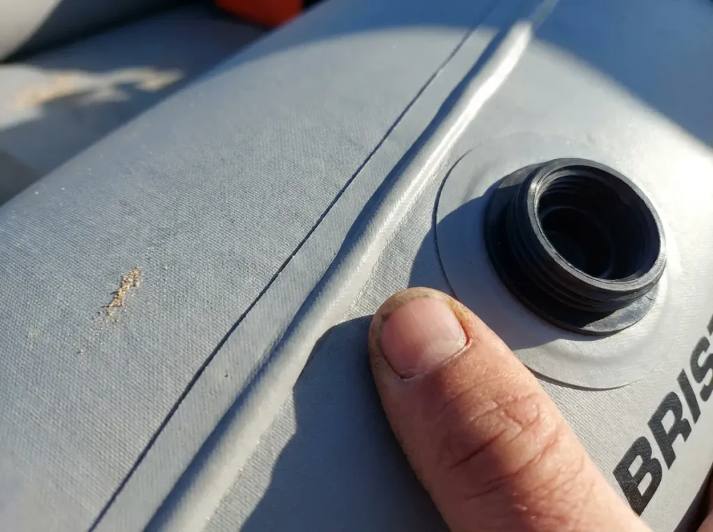 Close-up of a welded PVC seam and valve on a budget whitewater raft tube