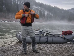 Best Drysuits for Rafting or Rent One First Rafter in a drysuit at a cold-water put-in checking gear before launch on a spring morning