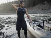 Best Wetsuits for Whitewater Rafting Not Dive Suits Rafter in a 3mm Farmer John wetsuit rigging an oar frame on a cold spring river at dawn