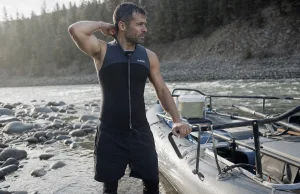 Best Wetsuits for Whitewater Rafting Not Dive Suits Rafter in a 3mm Farmer John wetsuit rigging an oar frame on a cold spring river at dawn