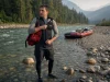 What to Wear Rafting Summer vs Spring Runoff Rafter in a wetsuit at a cold snowmelt put-in on a warm summer morning