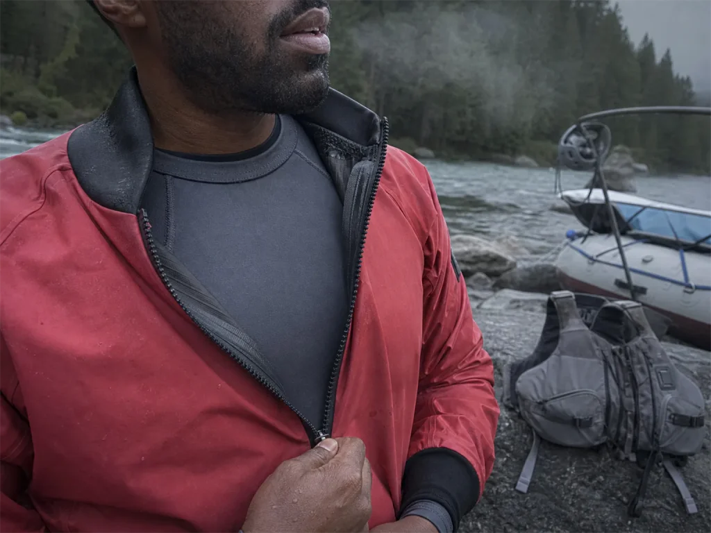 Rafter zipping a splash jacket over a base layer showing where the base layer fits in the layering system