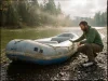 How Long Do Rafts Last? Longer Than You Think Weathered older whitewater raft drying on a gravel bar, showing how long a well-kept raft lasts