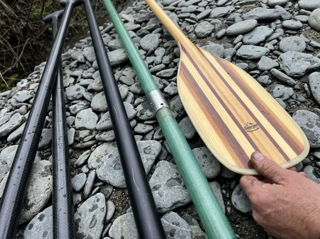 Carbon, aluminum, fiberglass and wood paddle shafts laid side by side to compare shaft materials