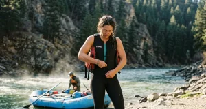 What to Wear Rafting When the Water’s Colder Than the Air Rafter at the put-in dressed for cold water in a wetsuit before a shoulder-season whitewater run